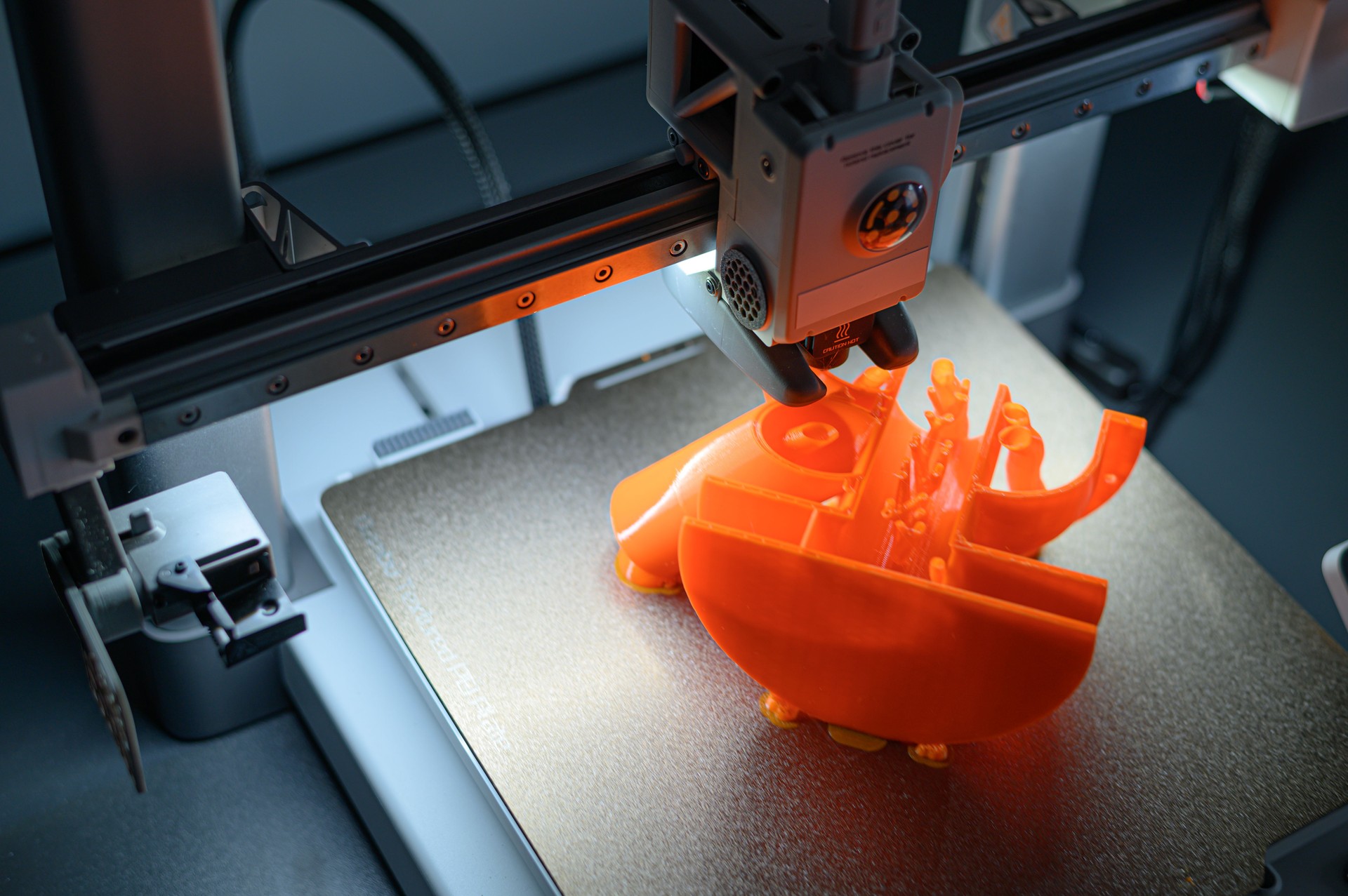 3D Printer Creating Vibrant Orange Prototype Model